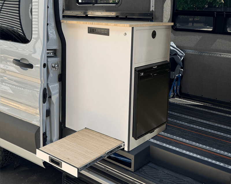 Load image into Gallery viewer, Oasis Compact 65L galley installed in van passenger door white cabinet bamboo slide-out table extended