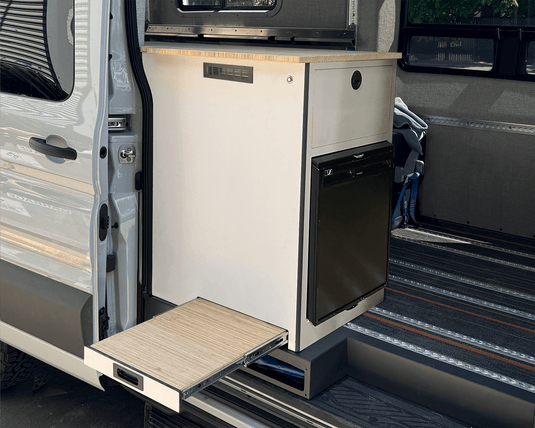 Oasis Compact 65L galley installed in van passenger door white cabinet bamboo slide-out table extended